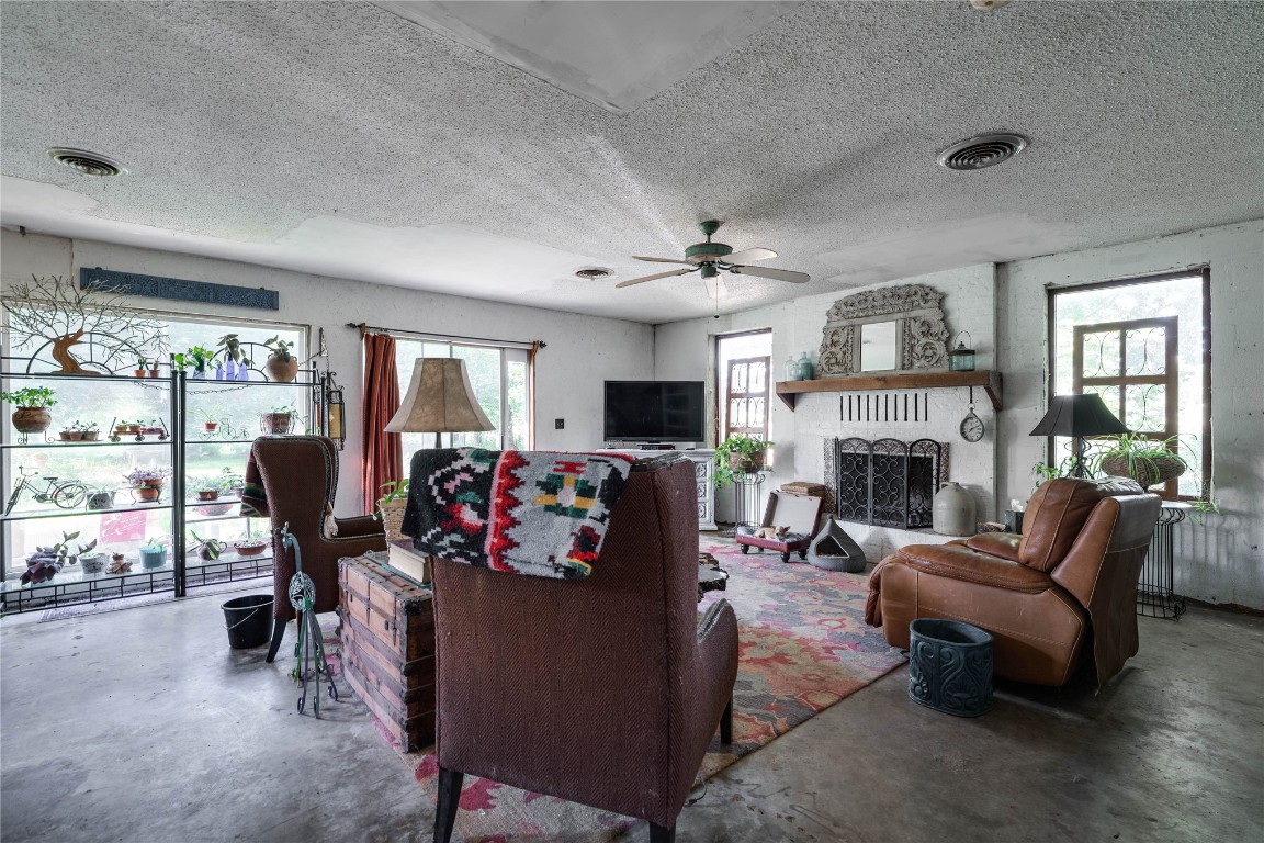 12345 SW 42nd Street, Mustang, OK 73064 living room featuring plenty of natural light, a ceiling fan, a fireplace, and TV
