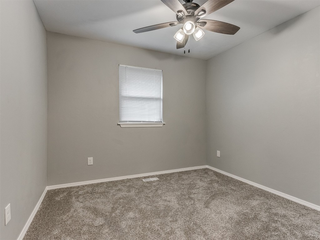 608 SW 26th Street, El Reno, OK 73036 empty room featuring carpet, a ceiling fan, and natural light
