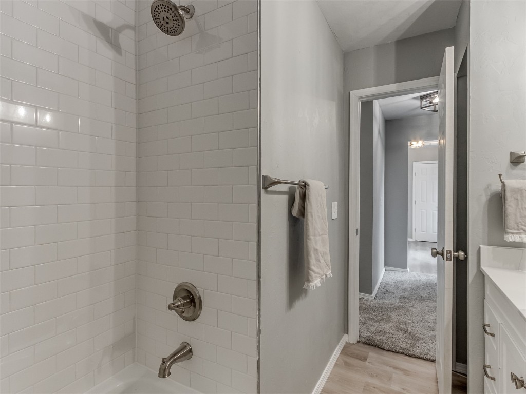 608 SW 26th Street, El Reno, OK 73036 bathroom with hardwood floors, vanity, and shower / bathing tub combination