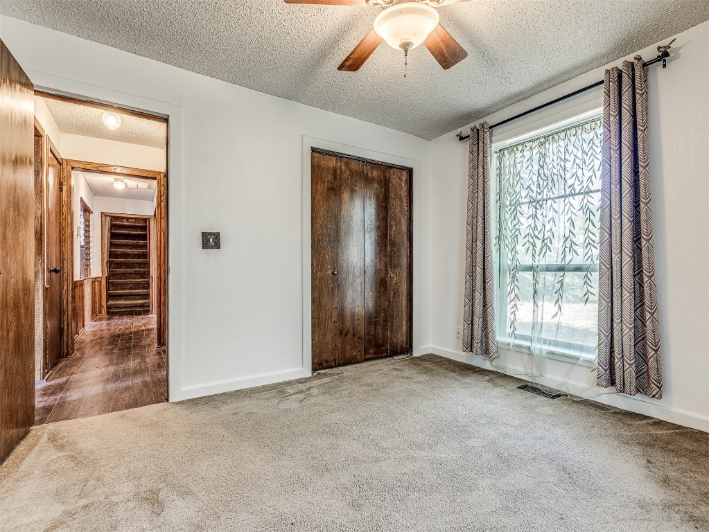 3305 NW 41st Street, Oklahoma City, OK 73112 interior space with a textured ceiling, multiple windows, ceiling fan, and light carpet