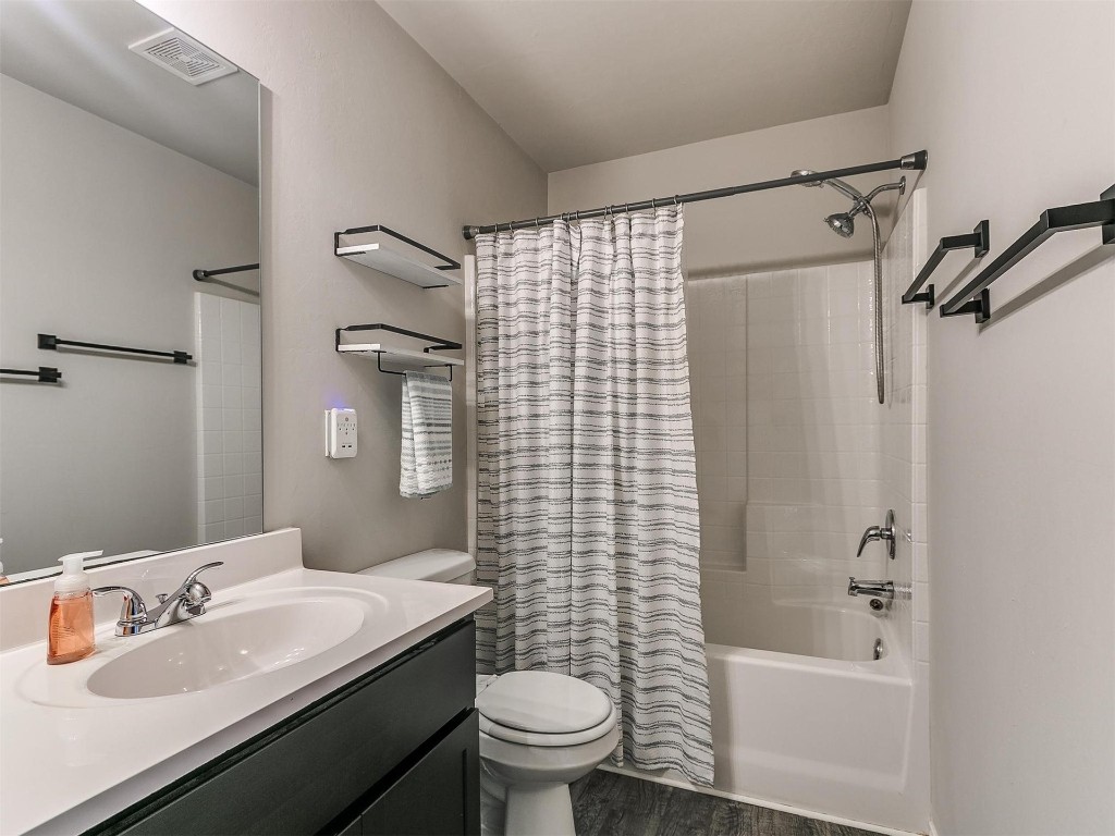 9521 NW 121st Street, Yukon, OK 73099 full bathroom with tile flooring, bathing tub / shower combination, vanity, shower curtain, mirror, and toilet