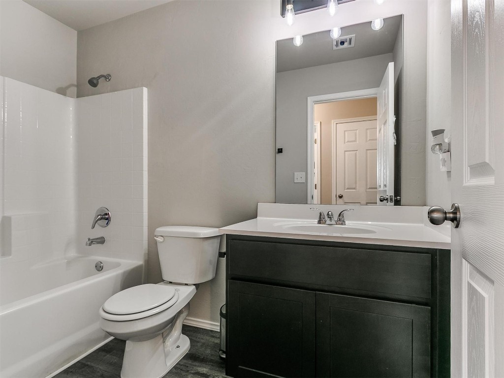 9521 NW 121st Street, Yukon, OK 73099 full bathroom with toilet, mirror, vanity, and shower / washtub combination