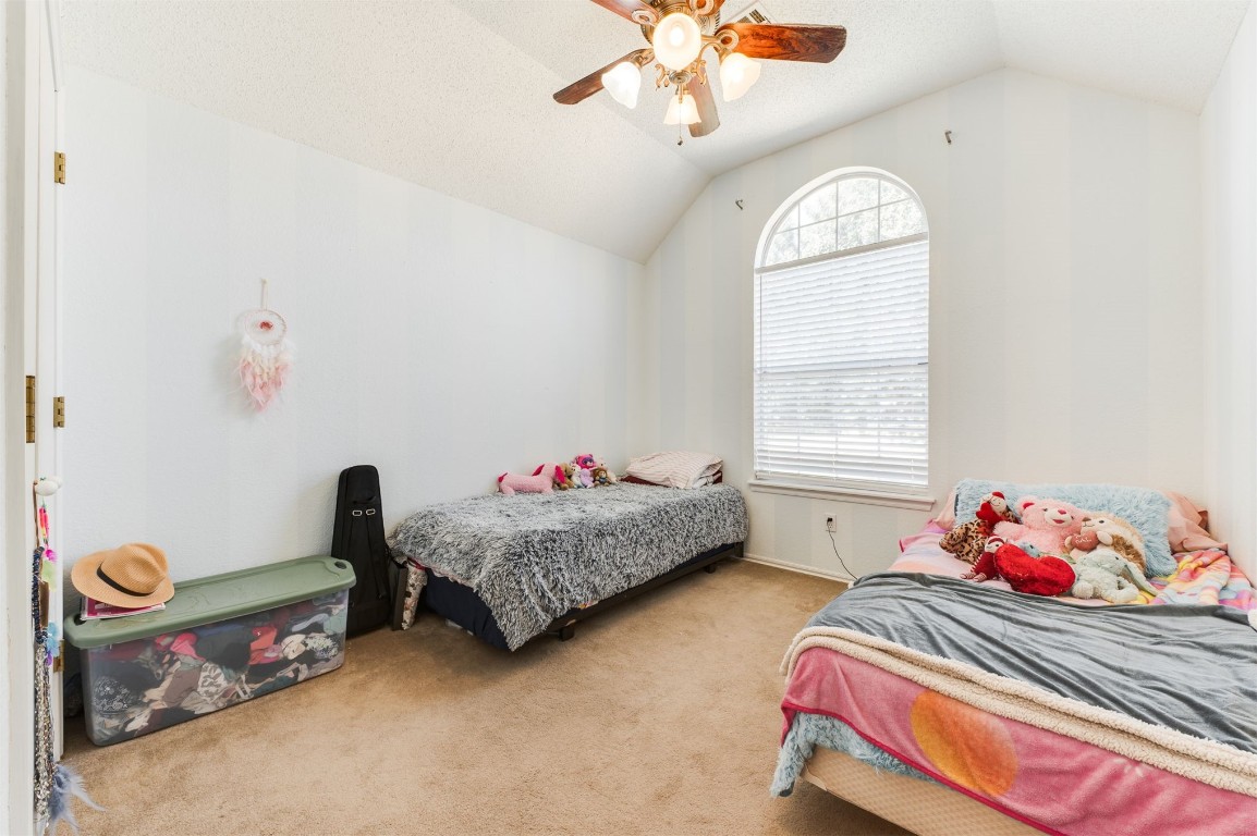 9306 Buttonfield Avenue, Moore, OK 73160 carpeted bedroom with vaulted ceiling and ceiling fan