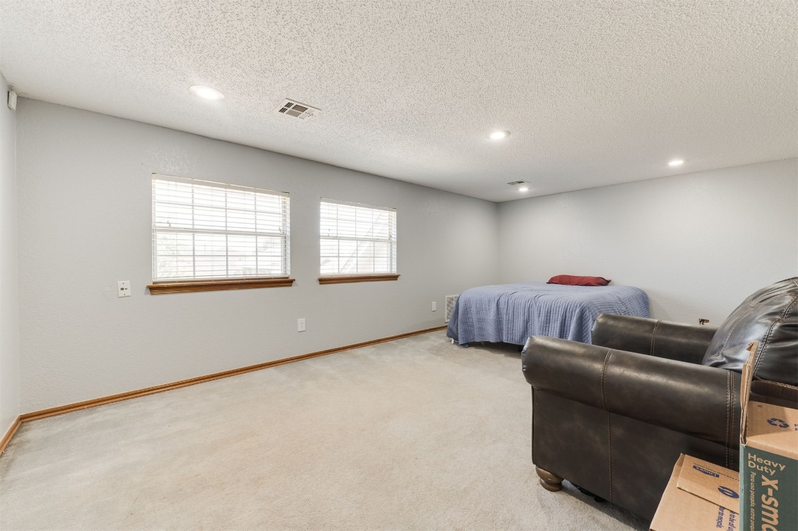 9306 Buttonfield Avenue, Moore, OK 73160 bedroom with light carpet and a textured ceiling