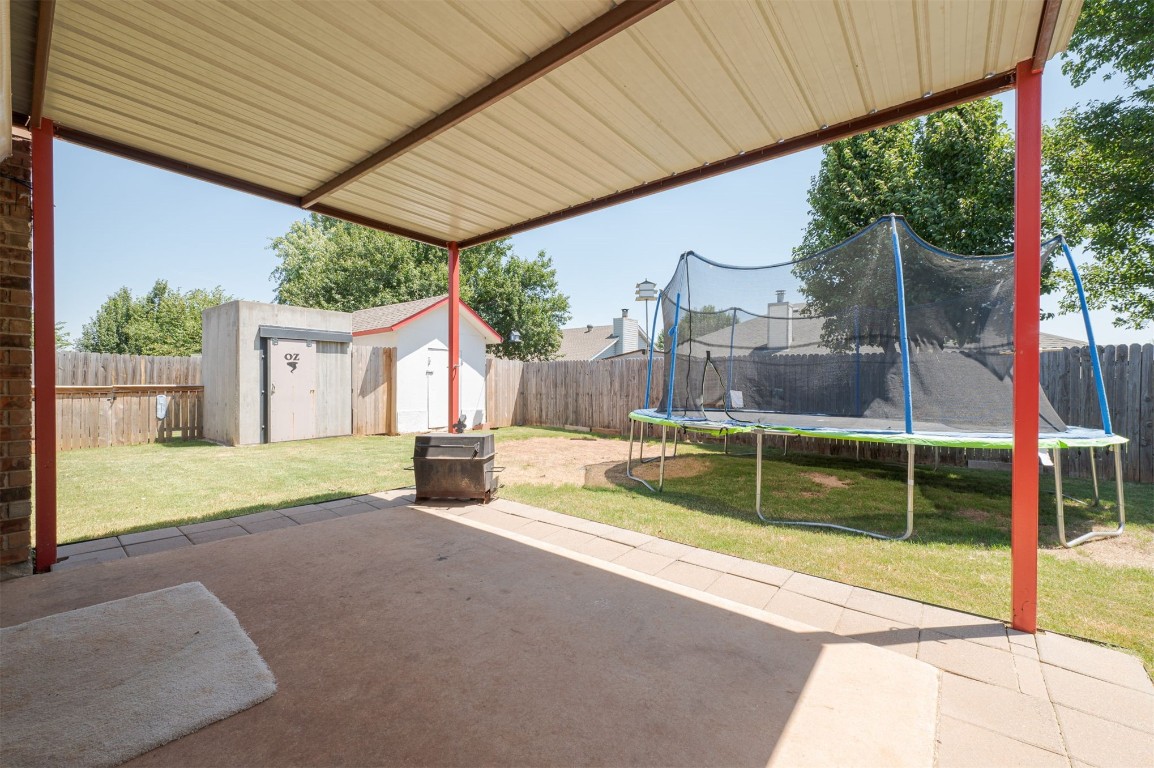 9306 Buttonfield Avenue, Moore, OK 73160 view of patio / terrace featuring a trampoline and a storage unit
