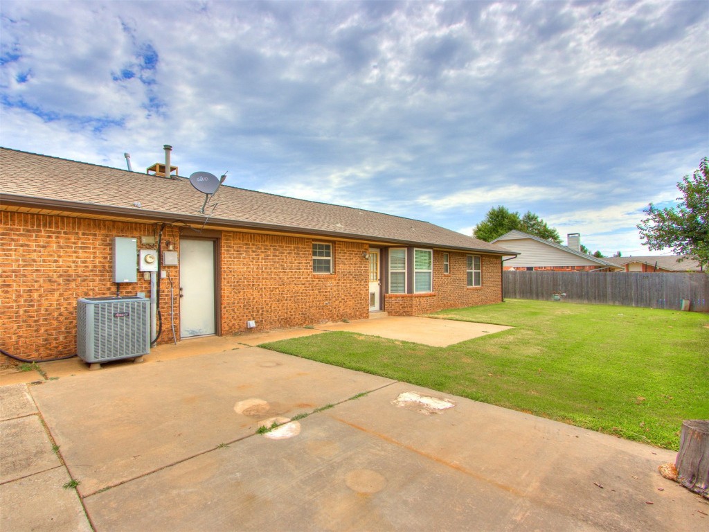 716 Lonnie Lane, Moore, OK 73170 rear view of house with central air condition unit, a lawn, and a patio area