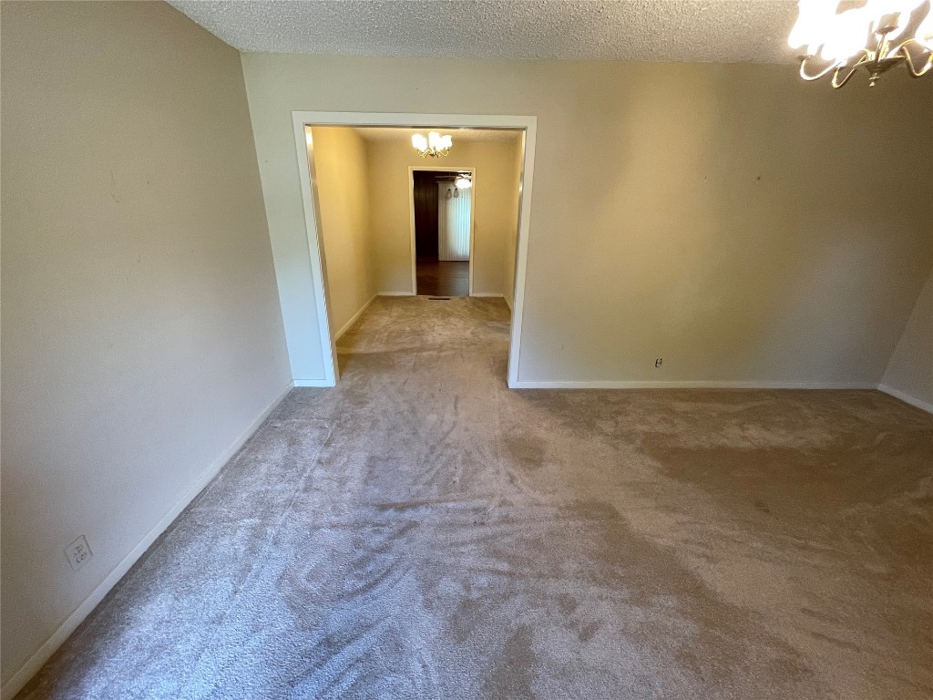 1815 Park Avenue, Chickasha, OK 73067-4505 empty room featuring light carpet and a textured ceiling