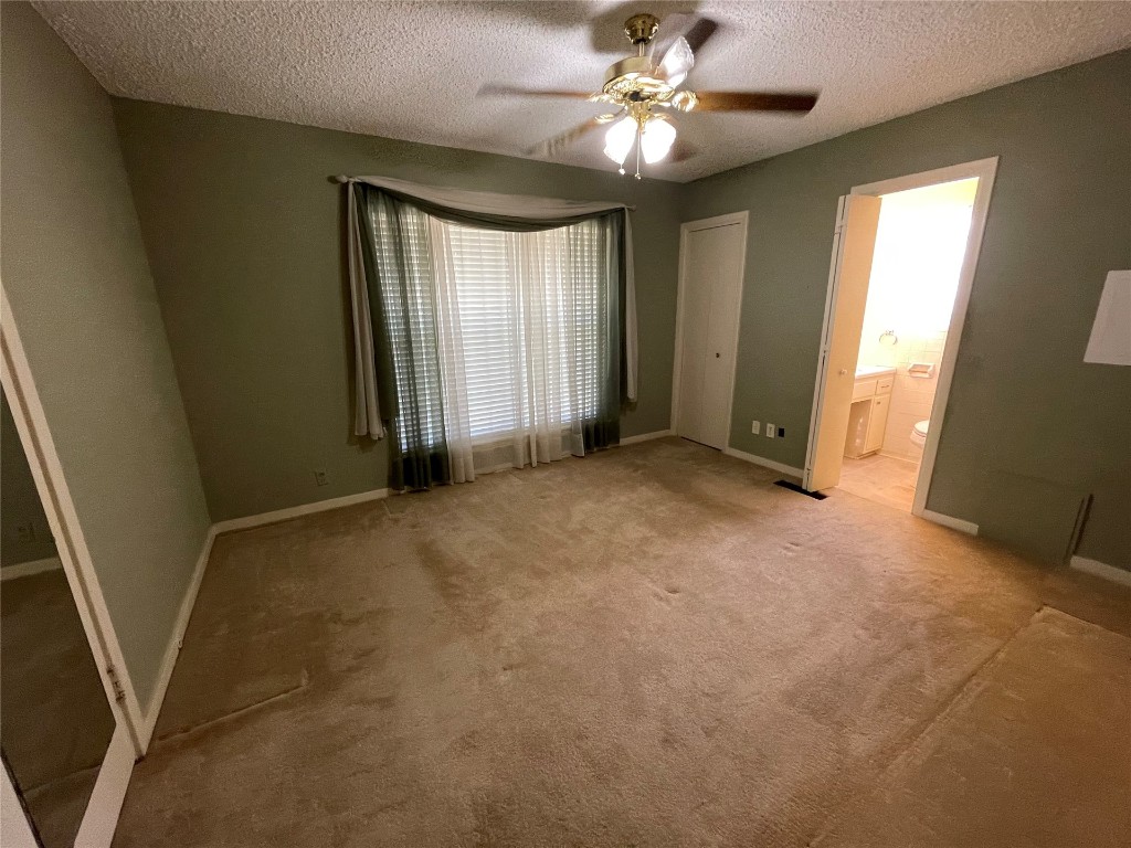 1815 Park Avenue, Chickasha, OK 73067-4505 unfurnished room with ceiling fan, light carpet, and a textured ceiling