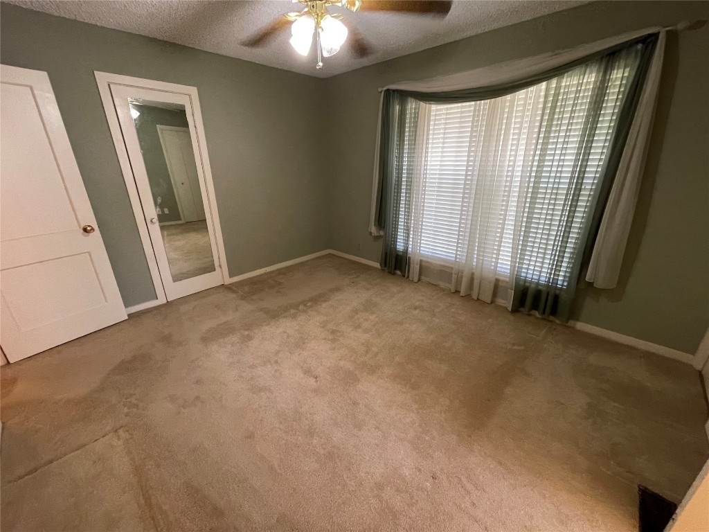 1815 Park Avenue, Chickasha, OK 73067-4505 carpeted spare room featuring ceiling fan and a textured ceiling