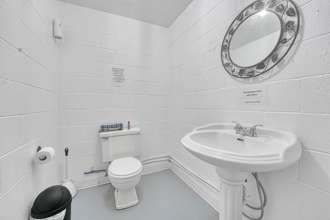 514 N Van Buren, Elk City, OK 73644 bathroom with sink, mirror, and a textured ceiling