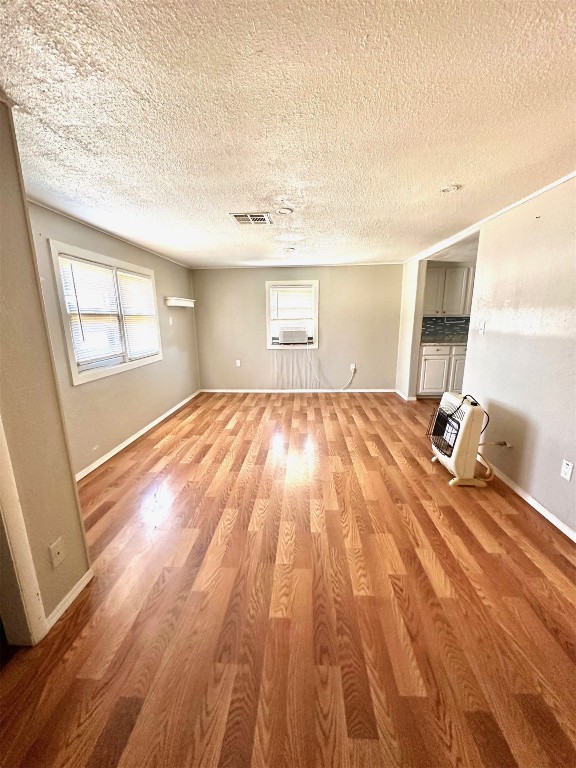 1208 S Grand, Ninnekah, OK 73067 unfurnished room featuring a textured ceiling and light hardwood / wood-style floors
