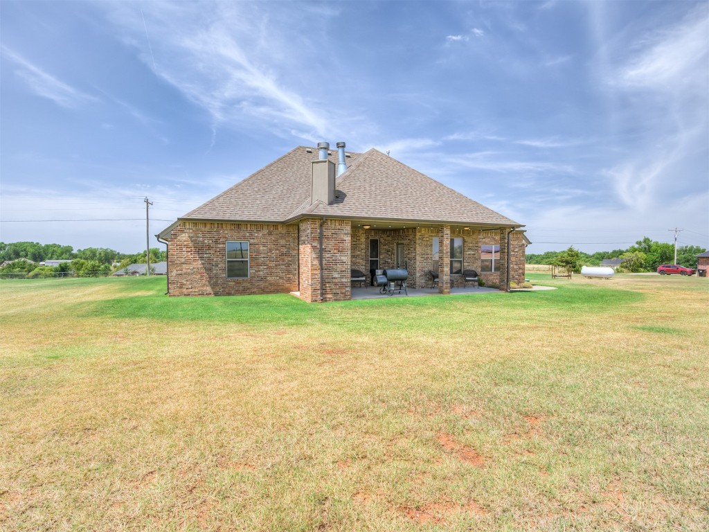 1123 S Czech Hall Road, Tuttle, OK 73089 rear view of property with a patio and a lawn