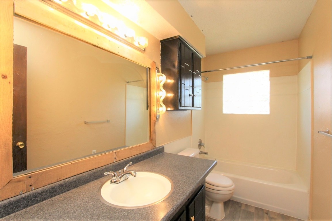 301 E Forest Lane, Mustang, OK 73064 full bathroom featuring light hardwood flooring, bathtub / shower combination, mirror, and vanity