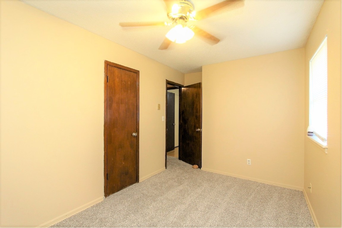301 E Forest Lane, Mustang, OK 73064 unfurnished room with light carpet and ceiling fan