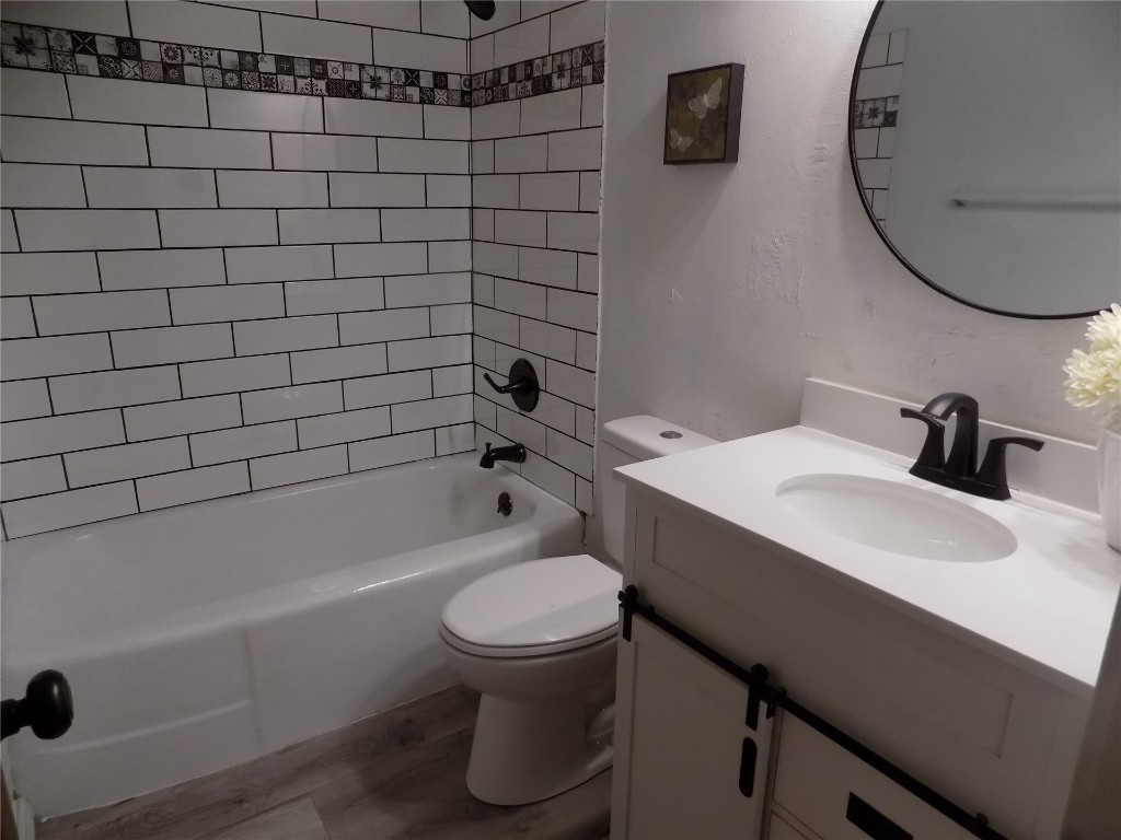 2402 Townsend Drive, El Reno, OK 73036 full bathroom featuring hardwood flooring, vanity, mirror, and tiled shower / bath