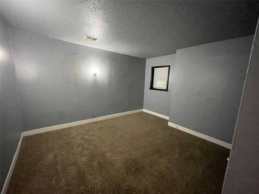 2221 NW 13th Street, Oklahoma City, OK 73107 unfurnished room with a textured ceiling and carpet flooring