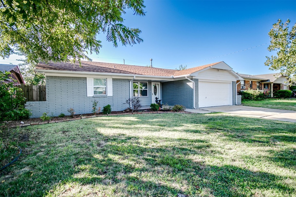 2600 SW 65th Street, Oklahoma City, OK 73159 ranch-style home with a front yard and garage