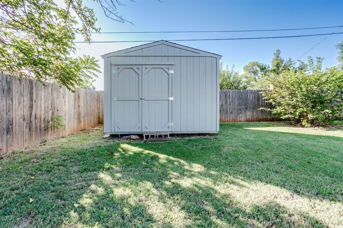 2600 SW 65th Street, Oklahoma City, OK 73159 view of shed / structure featuring a lawn and a storage shed