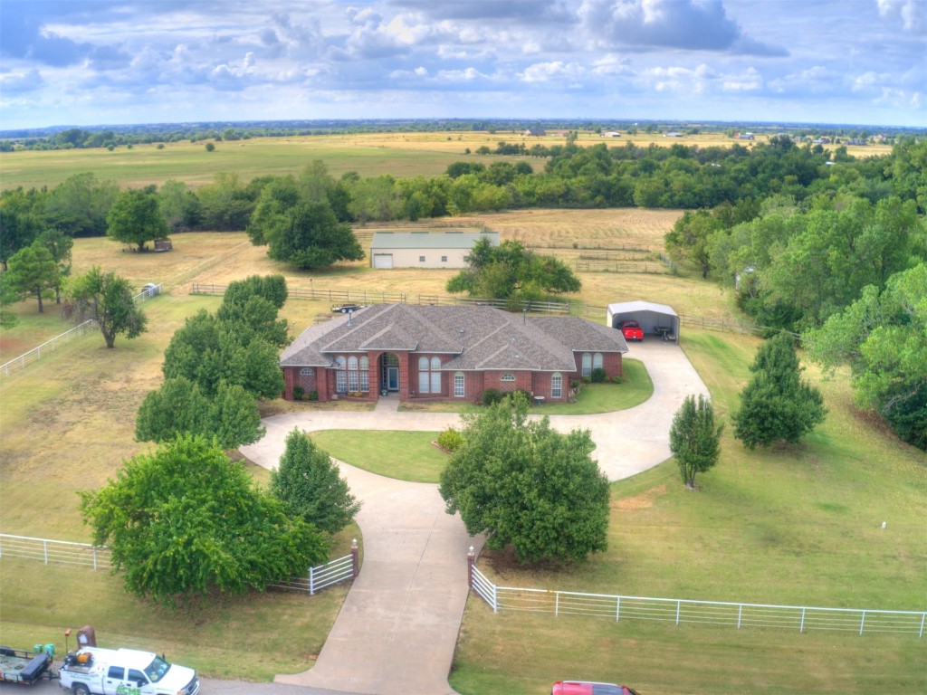 Over 8 acres, 8 stall horse barn w/tack room & wash bay, pond, generator, above ground pool w/deck, storm shelter, circle drive, 3 car garage & 2 car carport. Come check out this spacious home w/a list of amenities you'll love. Spacious study w/Wanescoating & vaulted ceiling. Large Formal dining or living. Entertainers kitchen open to the main living area has breakfast bar, island cooktop, large pantry & lots of cabinet & counter space. Wood burning fireplace w/blower, built-in bookcases, ceiling fan & patio access help make this space welcoming. The primary suite also has built-ins & a full bath w/his & her vanities, full tile walk-in shower & his & her walk-in closets. You just gotta come check this one out if you're looking for land, space & horse accomodations!