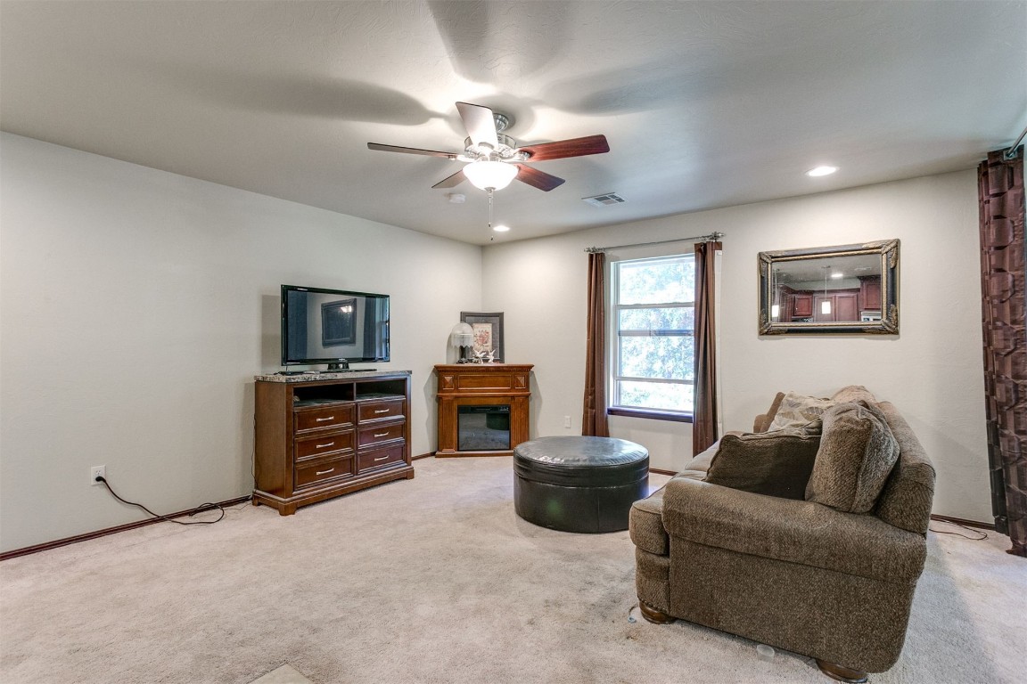 3324 Oakbriar Drive, Choctaw, OK 73020 living room featuring carpet flooring, a fireplace, and ceiling fan