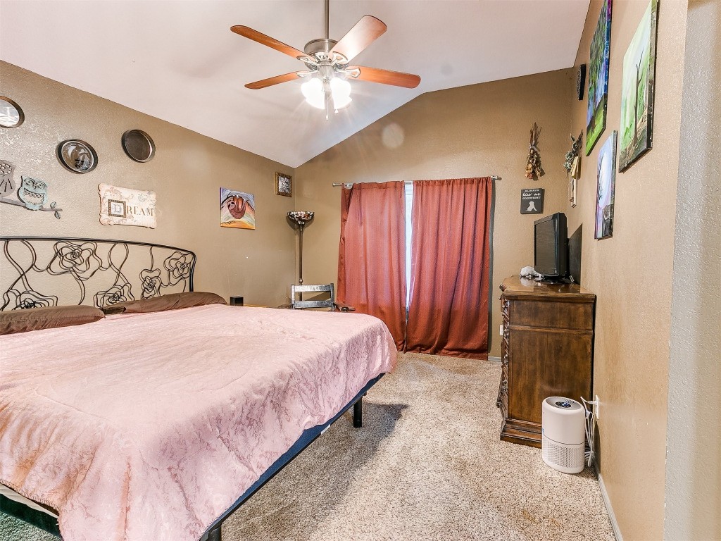 903 Valley Court, Edmond, OK 73012 carpeted bedroom featuring vaulted ceiling and ceiling fan