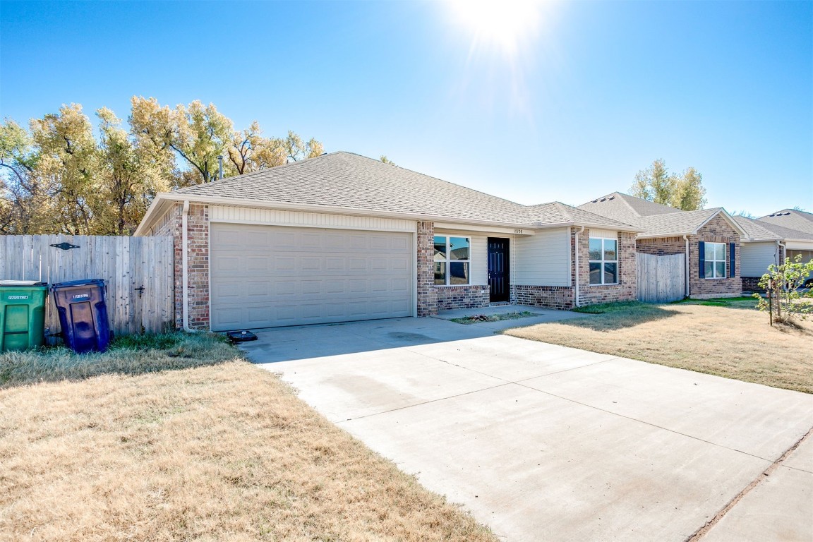 10708 SW 23rd Place, Yukon, OK 73099 ranch-style home with a front yard and a garage