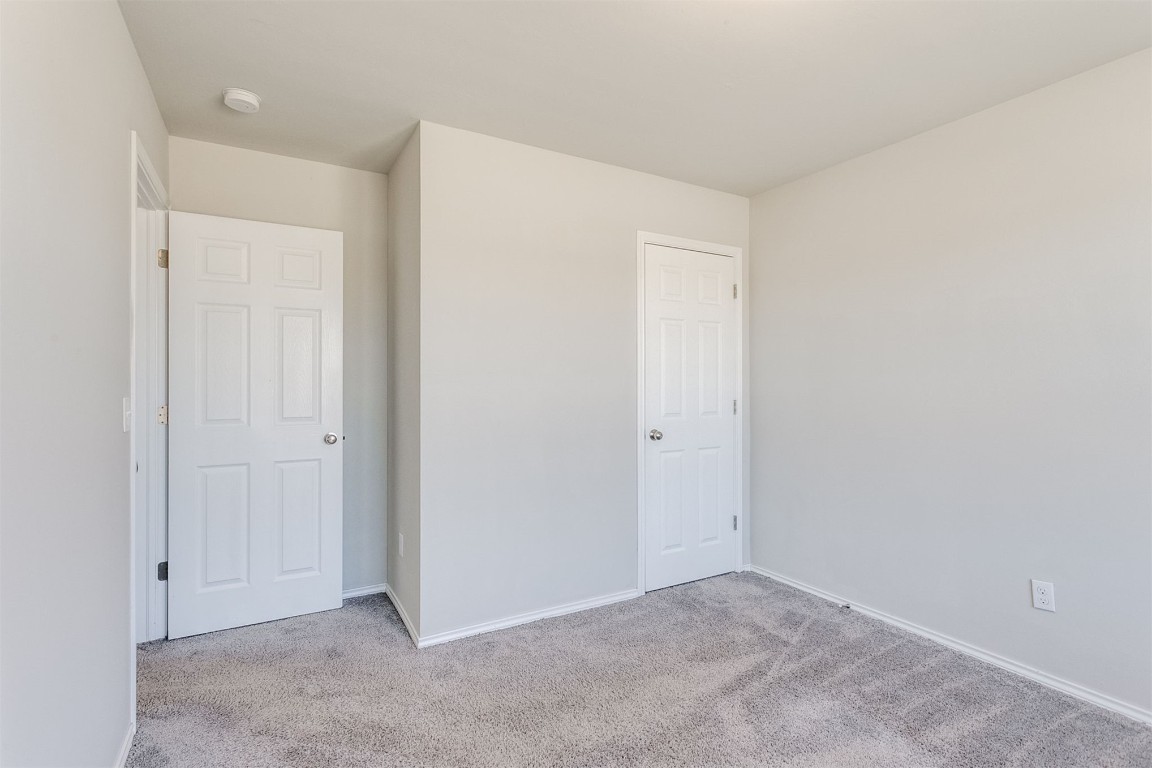 10708 SW 23rd Place, Yukon, OK 73099 unfurnished bedroom with light colored carpet and a closet