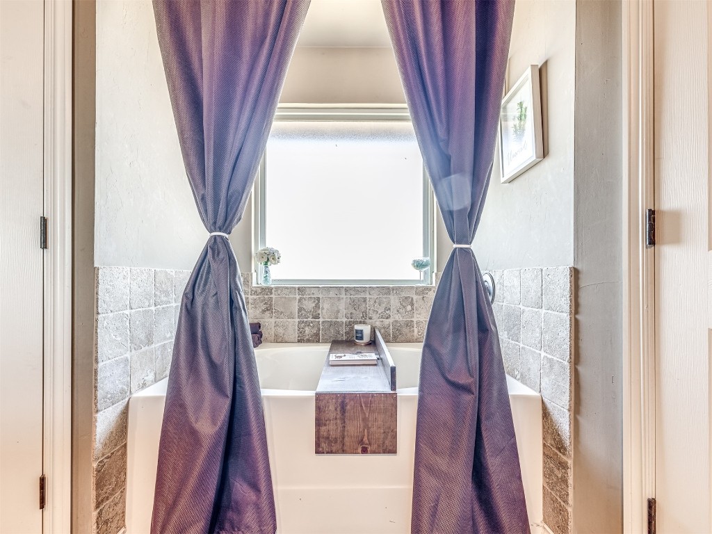 4205 Red Apple Terrace, Moore, OK 73160 bathroom featuring tile walls and a bath to relax in