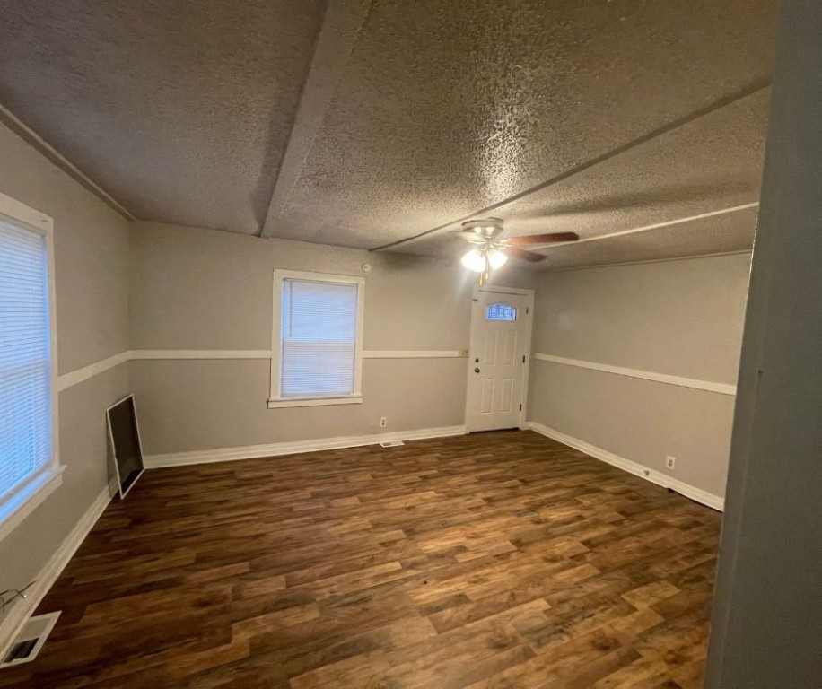 602 W Elm Street, El Reno, OK 73036 empty room with ceiling fan, a textured ceiling, and dark hardwood / wood-style flooring