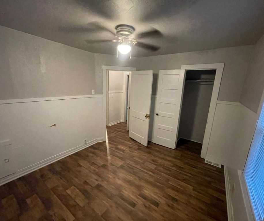 602 W Elm Street, El Reno, OK 73036 unfurnished bedroom featuring dark hardwood / wood-style flooring, a closet, and ceiling fan