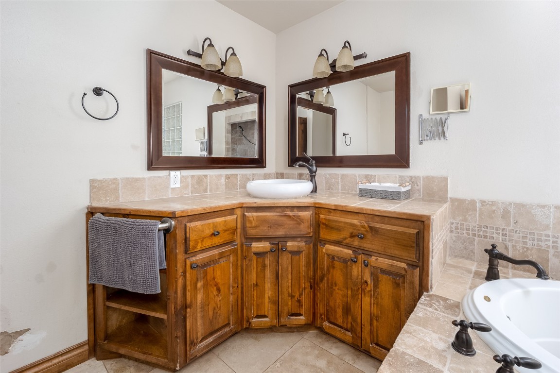 715 Edgewood Drive, Choctaw, OK 73020 bathroom with vanity, a bathtub, tile flooring, and backsplash