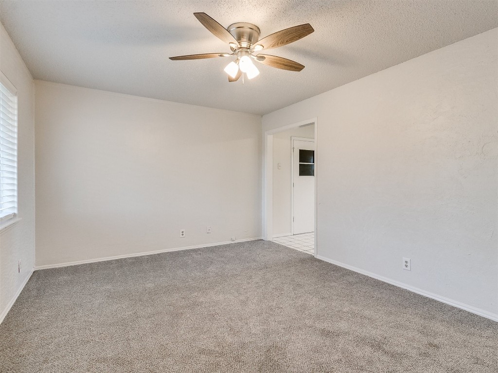 813 S Meadow Lane, Mustang, OK 73064 carpeted spare room featuring ceiling fan and a textured ceiling