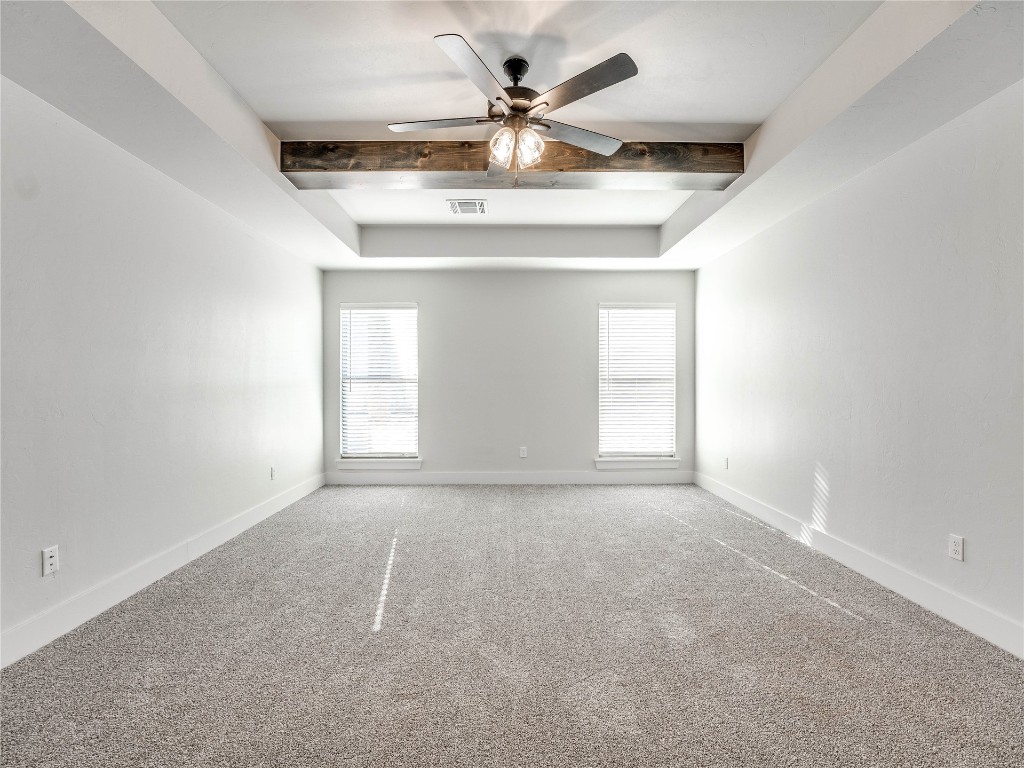 124 W Lynn Court Drive, Mustang, OK 73064 carpeted empty room featuring beam ceiling and ceiling fan