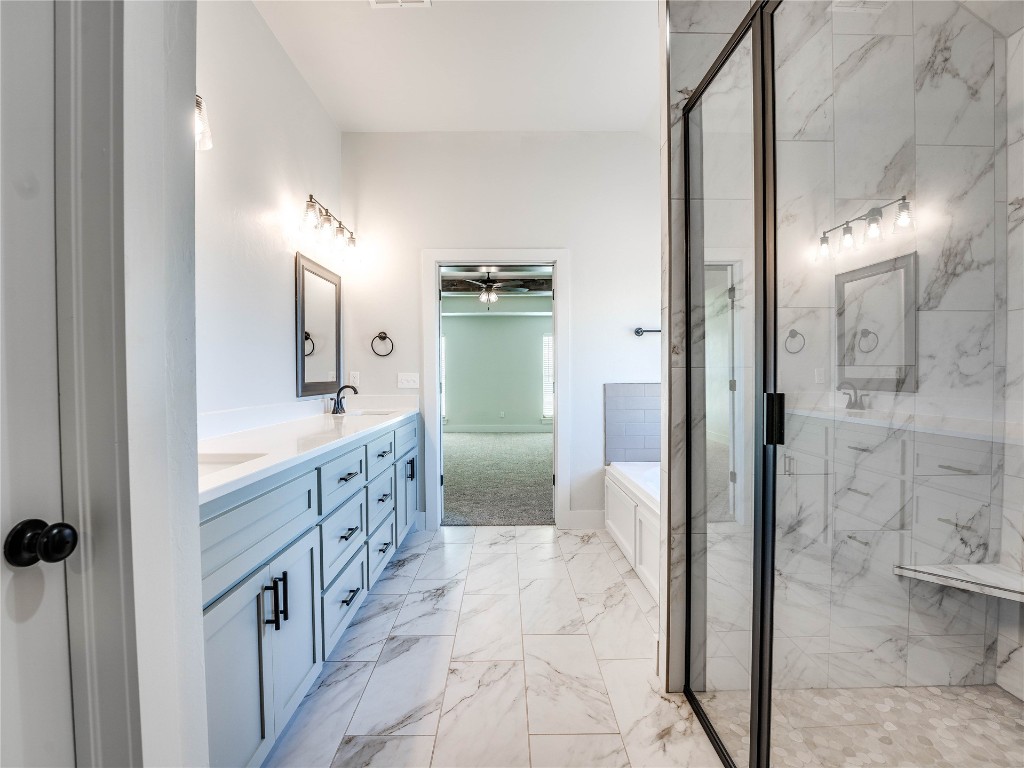 124 W Lynn Court Drive, Mustang, OK 73064 bathroom with dual sinks, plus walk in shower, tile floors, and large vanity