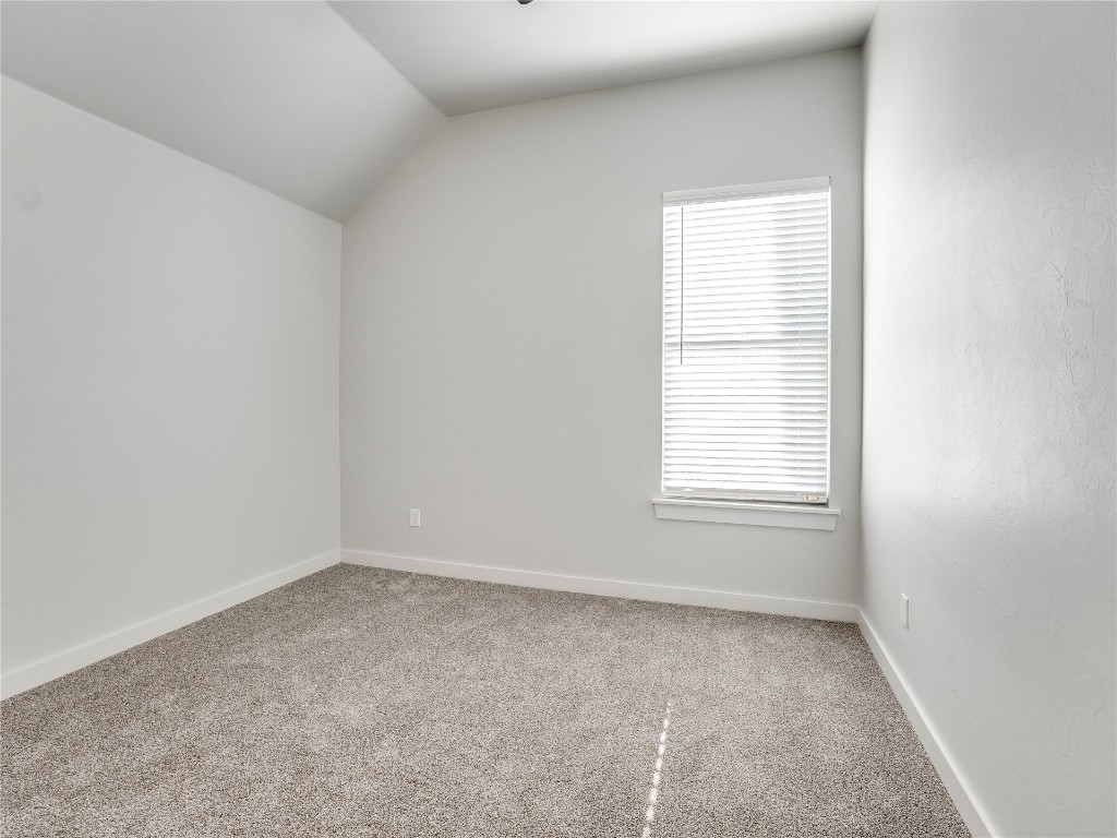 124 W Lynn Court Drive, Mustang, OK 73064 carpeted spare room featuring vaulted ceiling