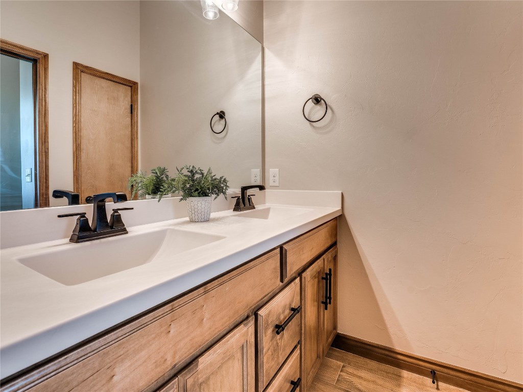 10517 NW 33rd Street, Yukon, OK 73099 bathroom with wood-type flooring and double vanity