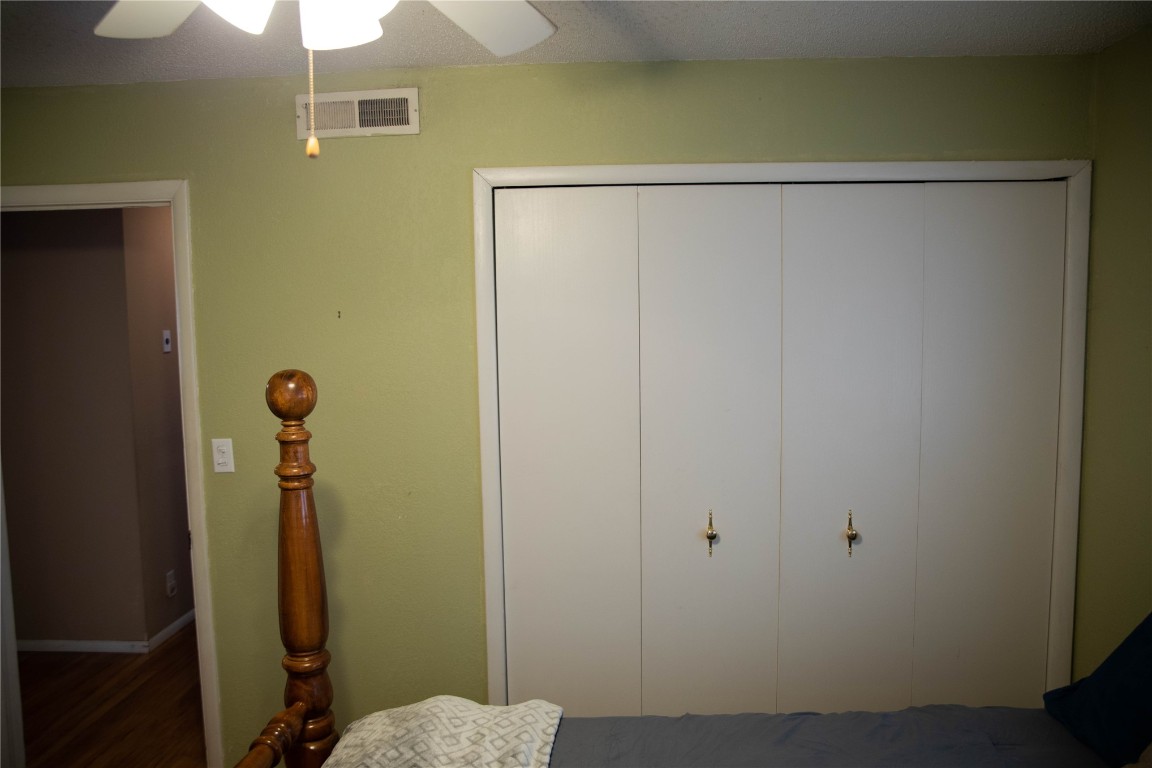 107 Cimarron Road, Burns Flat, OK 73647 bedroom featuring dark hardwood / wood-style floors, a closet, and ceiling fan