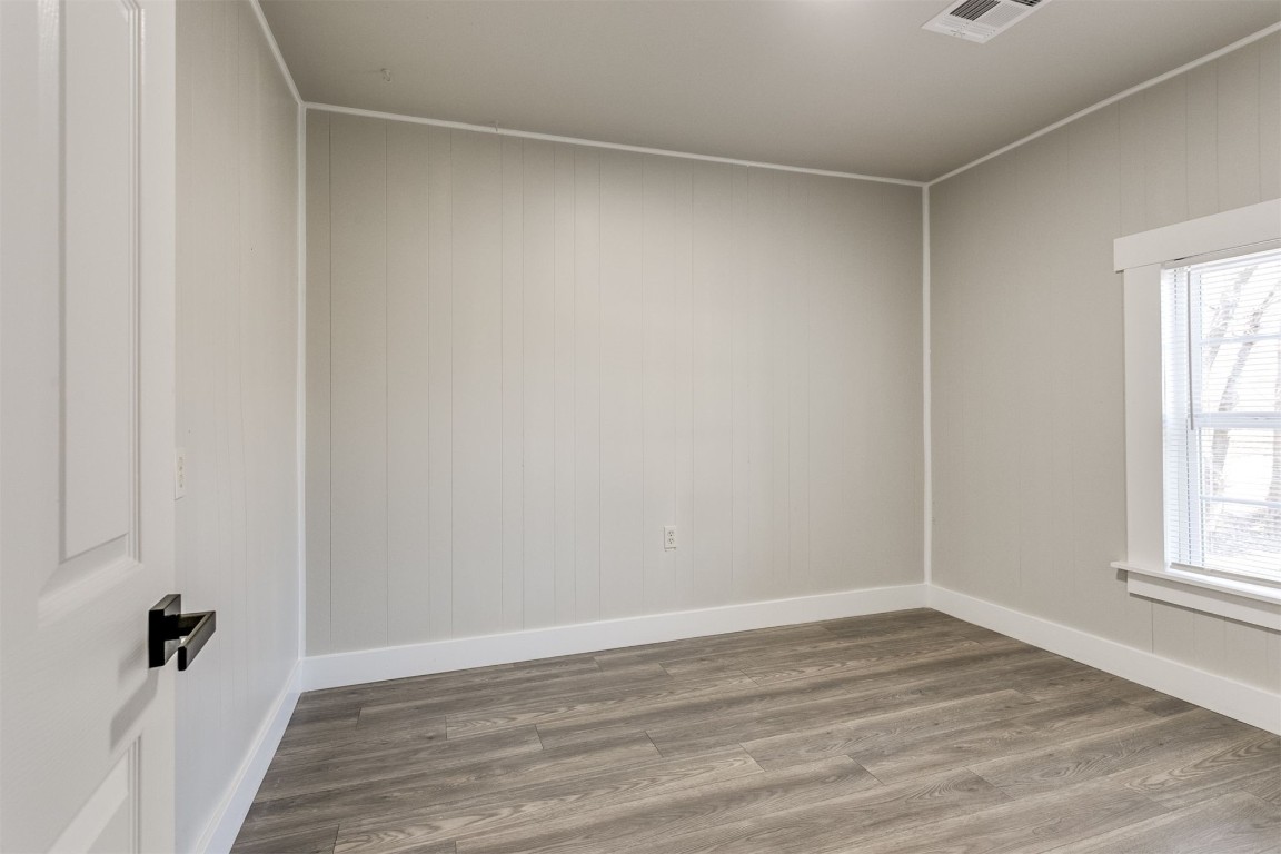 735 NW 90th Street, Oklahoma City, OK 73114 empty room featuring dark wood-type flooring and plenty of natural light