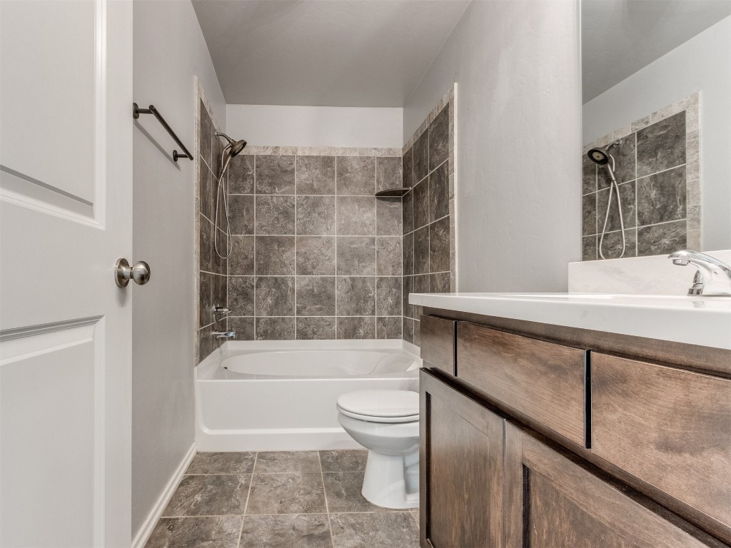 19241 Bajo Drive, Edmond, OK 73012 full bathroom featuring toilet, tile floors, tiled shower / bath, and vanity