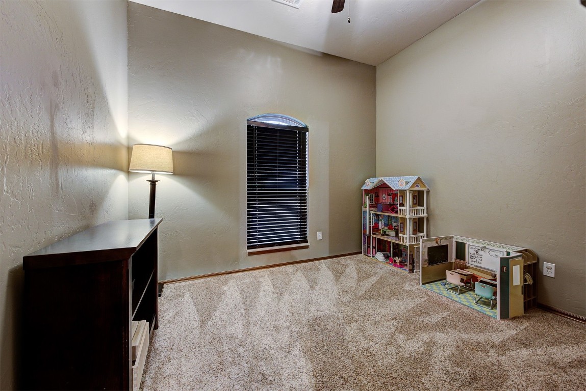 1304 Polly Way, Mustang, OK 73064 rec room featuring light carpet, ceiling fan, and vaulted ceiling