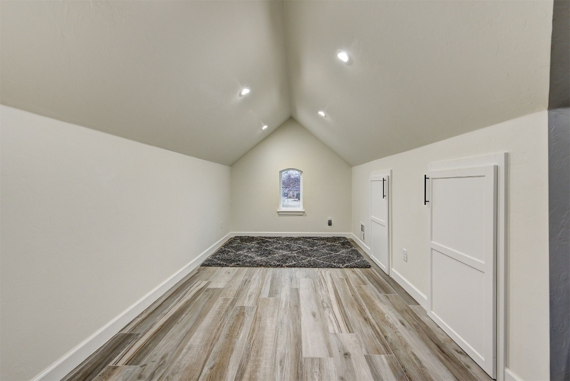 1304 Polly Way, Mustang, OK 73064 additional living space with light hardwood / wood-style flooring and vaulted ceiling