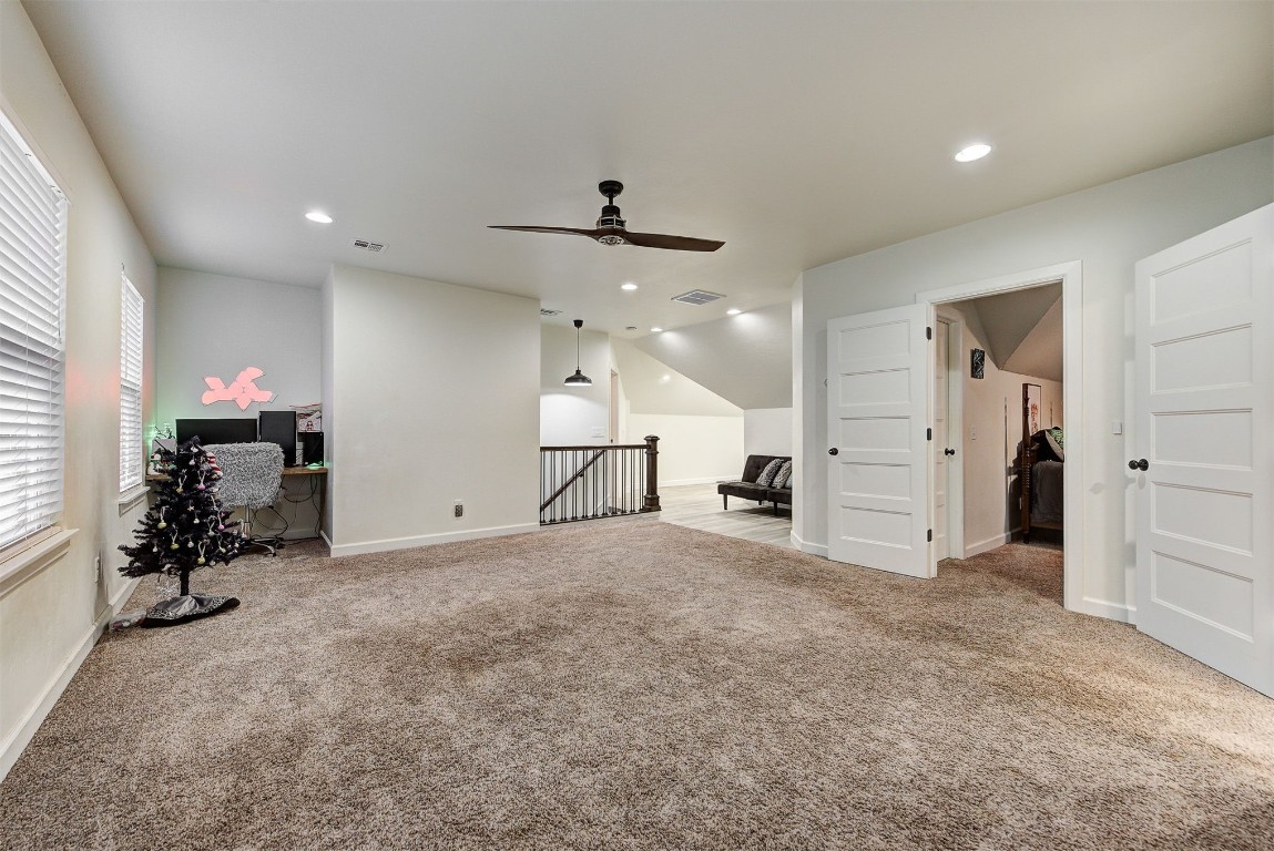 1304 Polly Way, Mustang, OK 73064 interior space with vaulted ceiling, ceiling fan, and light carpet