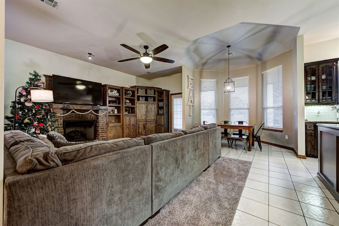 1304 Polly Way, Mustang, OK 73064 tiled living room featuring ceiling fan and a fireplace