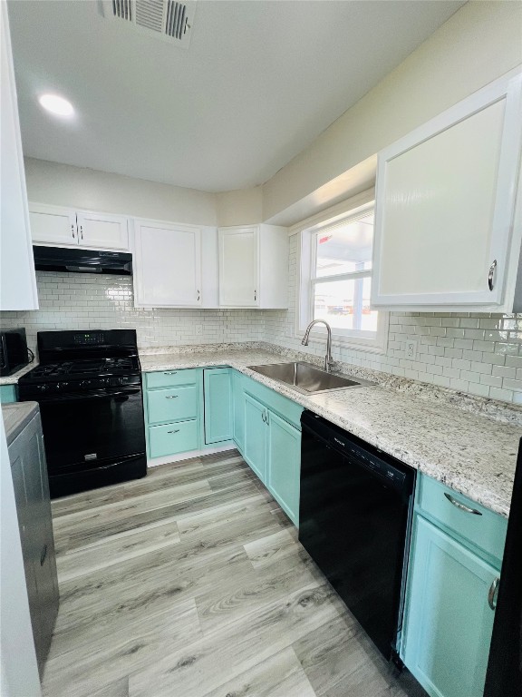 113 Osage Road, #B, Burns Flat, OK 73647 kitchen featuring sink, light hardwood / wood-style flooring, white cabinets, black appliances, and backsplash