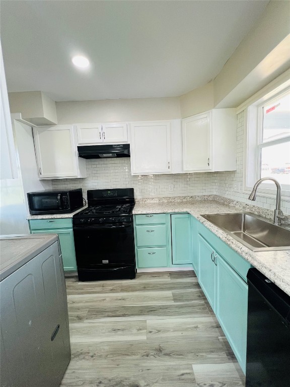 113 Osage Road, #B, Burns Flat, OK 73647 kitchen featuring white cabinets, sink, light hardwood / wood-style flooring, black appliances, and exhaust hood