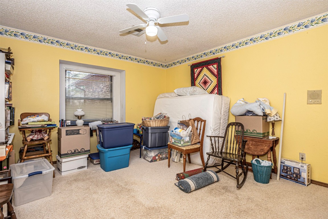 3735 Janet Circle, Mustang, OK 73064 miscellaneous room with light carpet, a textured ceiling, and ceiling fan