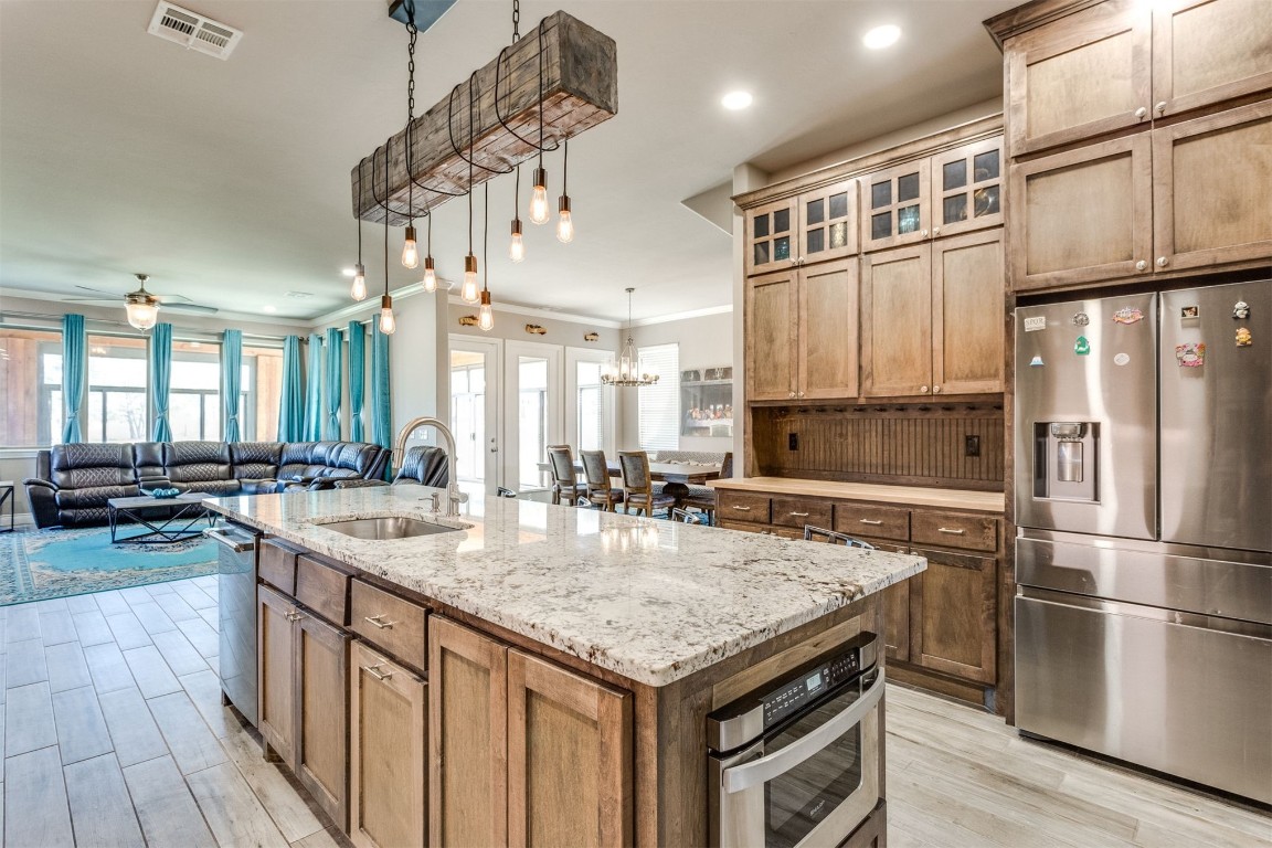 3910 Sienna Ridge, Newcastle, OK 73065 kitchen featuring ceiling fan with notable chandelier, appliances with stainless steel finishes, light hardwood / wood-style flooring, sink, and a kitchen island with sink