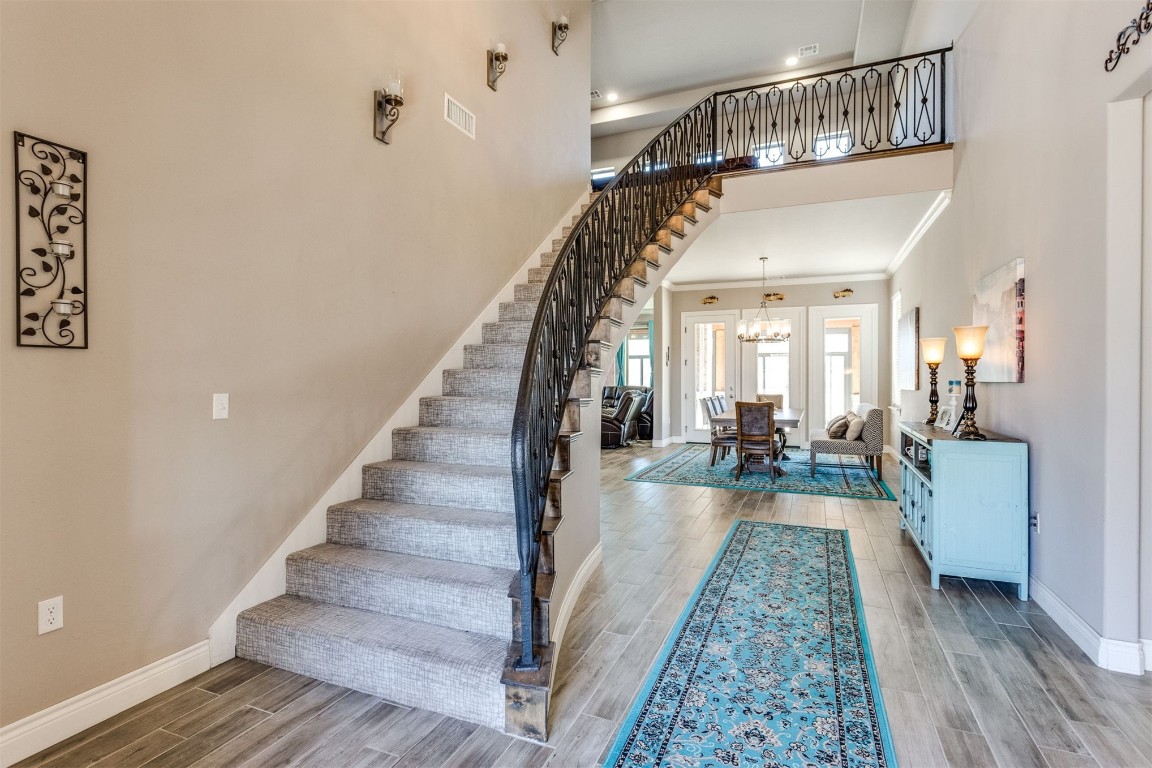 3910 Sienna Ridge, Newcastle, OK 73065 stairs with a chandelier, hardwood / wood-style floors, crown molding, and a high ceiling