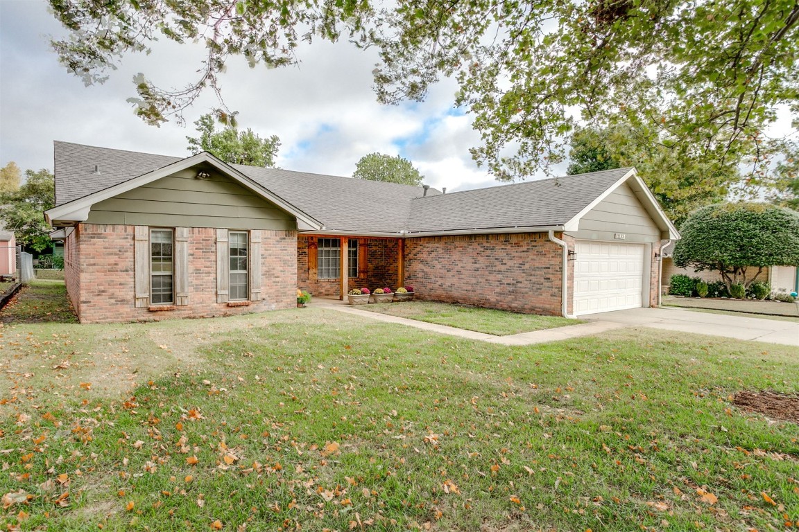 11133 Folkstone Drive, Yukon, OK 73099 single story home featuring a garage and a front yard