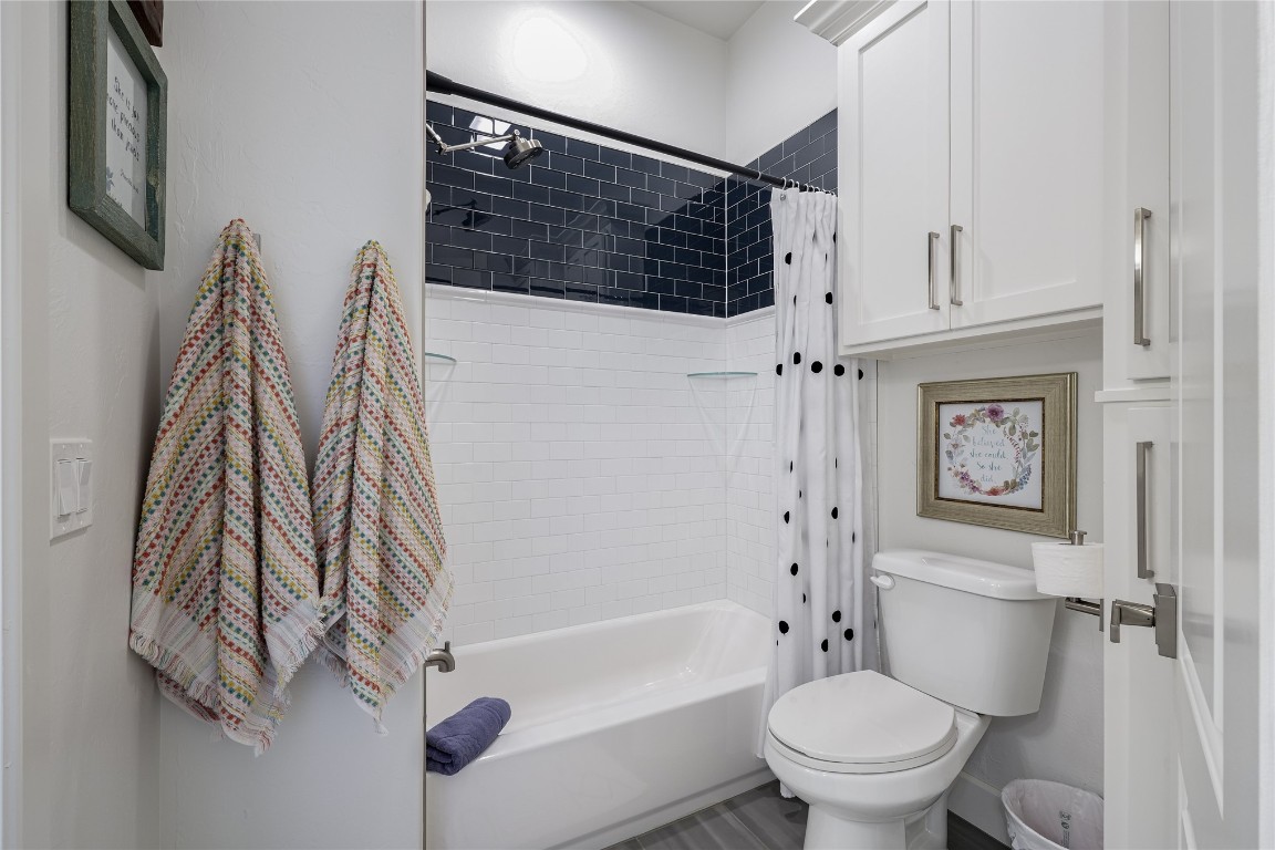 5008 Isle Bridge Court, Edmond, OK 73034 bathroom with toilet and shower / bath combo with shower curtain